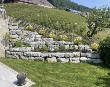 Mur de soutènement en pierres au-dessus d’une pelouse