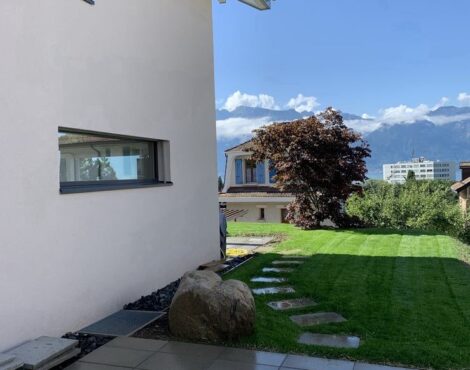 Terrasse et pelouse aménagées à côté d’une maison