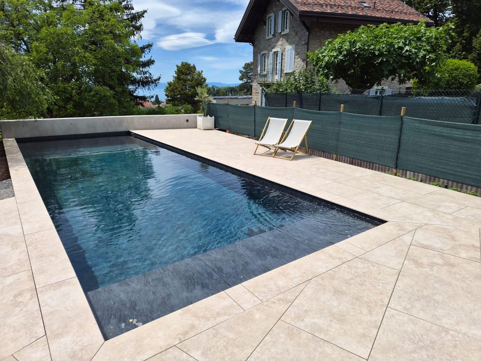 Vue d’ensemble de la piscine et de sa terrasse terminées à Saint-Légier
